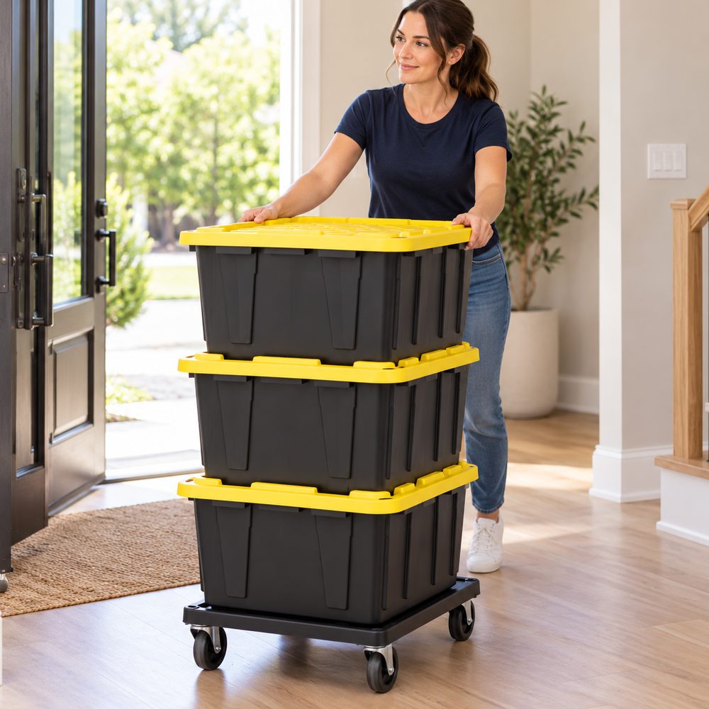 A woman rolling three packed totes with yellow lids on a dolly through her front hallway